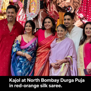 Kajol at the 80th North Bombay Durga Puja wearing a red-orange silk saree in Mumbai